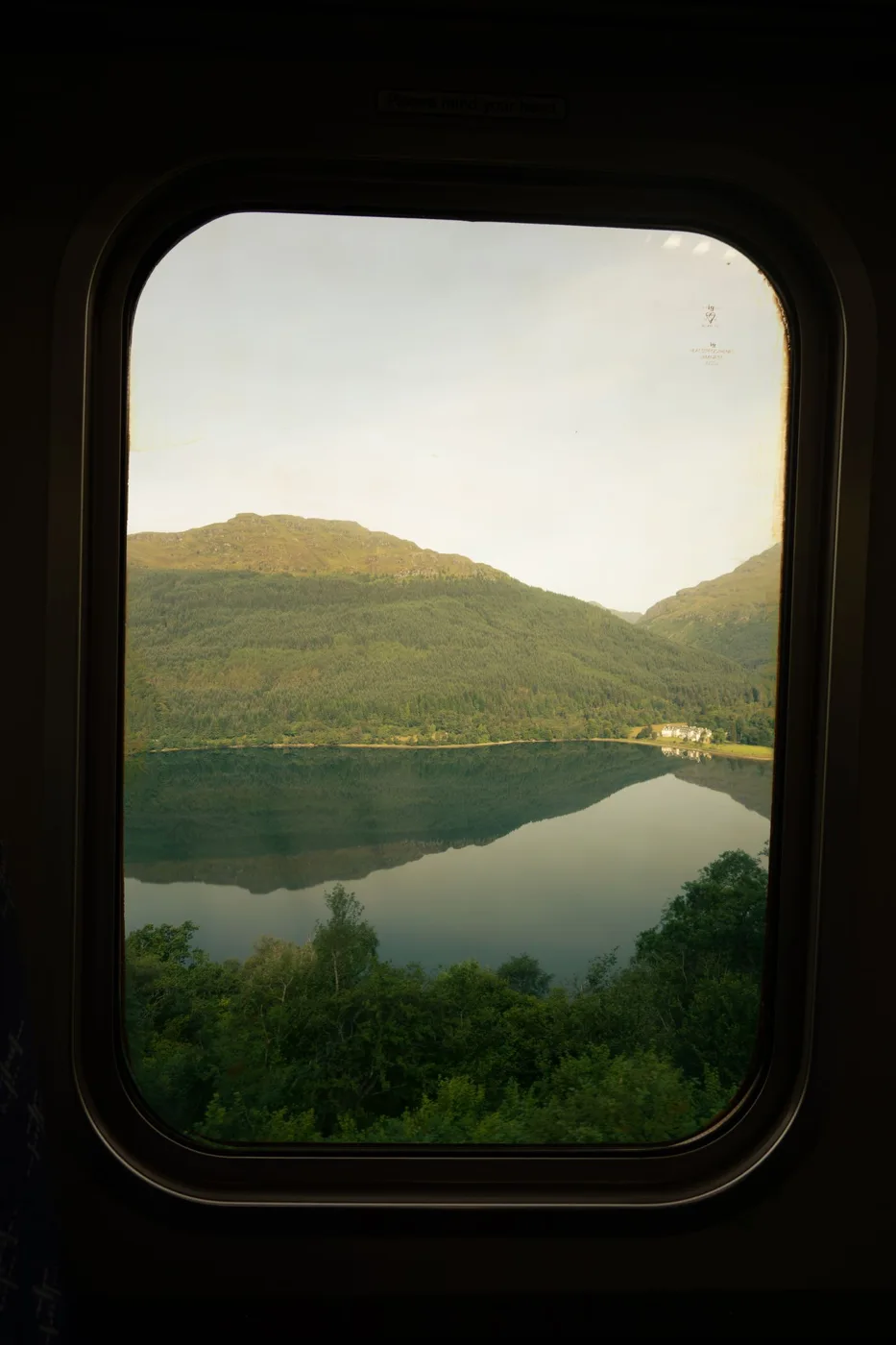 A mountain lake seen through a train window